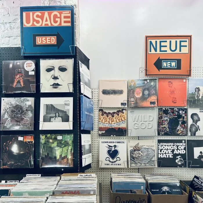Usagé/Used and Neuf/New signs over the new arrivals wall